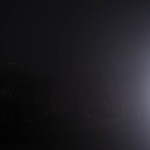 Blast of light/night: car headlight in foggy Wyoming night